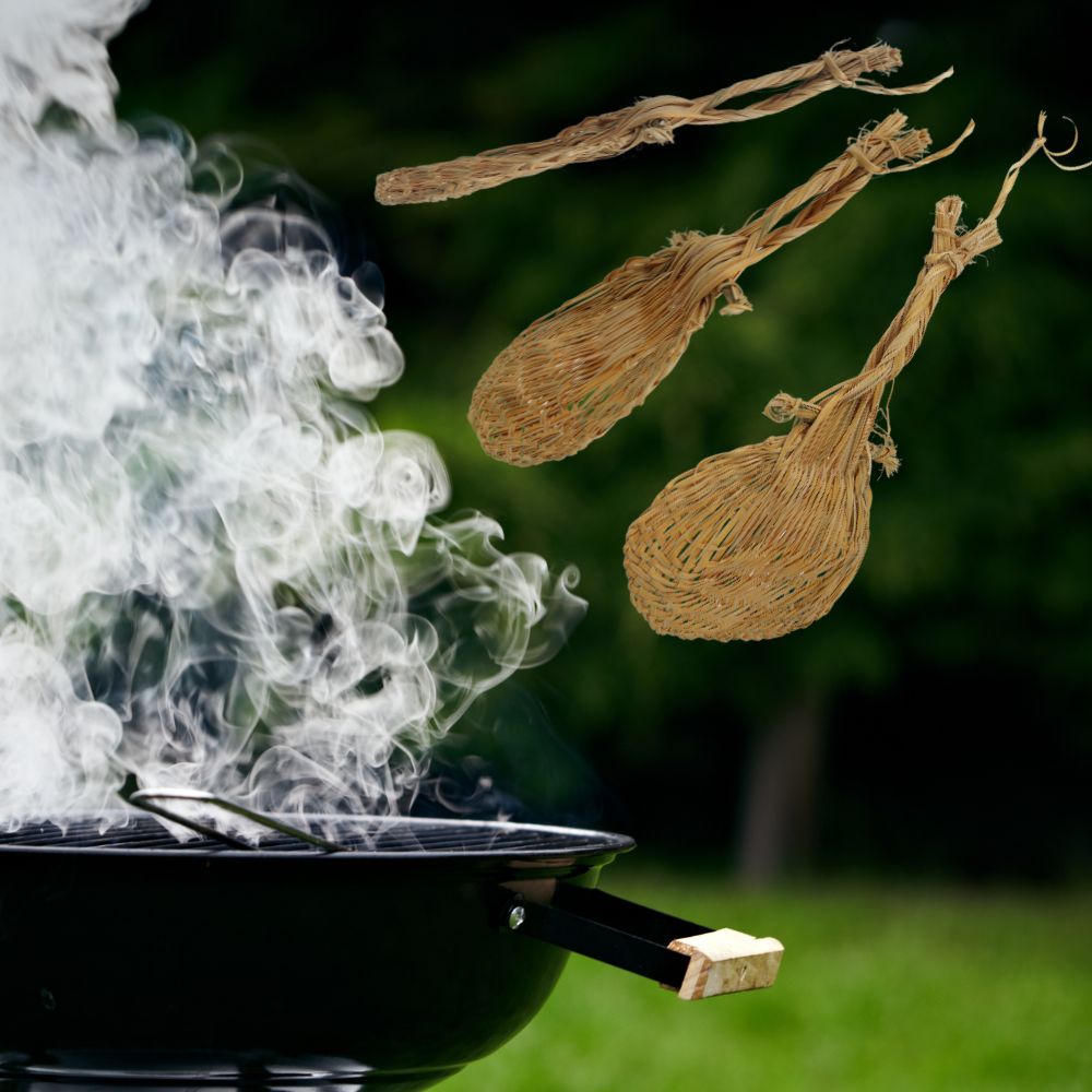 Drei handgefertigte Palmfächer aus dem Amazonas fliegen über einem Grill, verwendet zum Anfachen von Feuer.