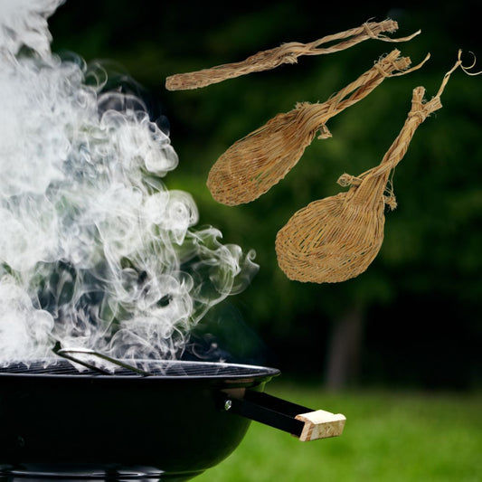 Drei handgefertigte Palmfächer aus dem Amazonas fliegen über einem Grill, verwendet zum Anfachen von Feuer.